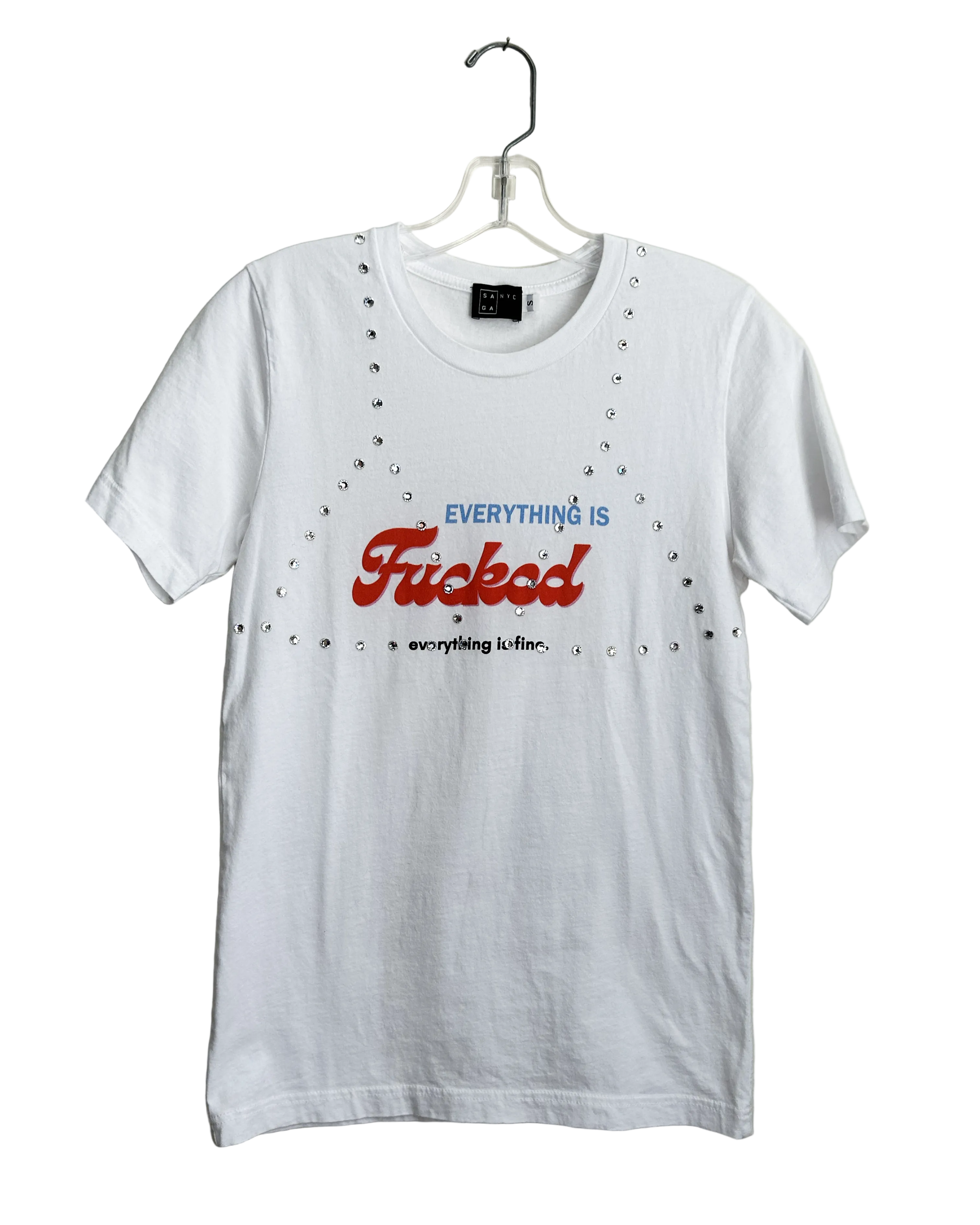 upcycled White t-shirt with text on a hanger against a beige wall